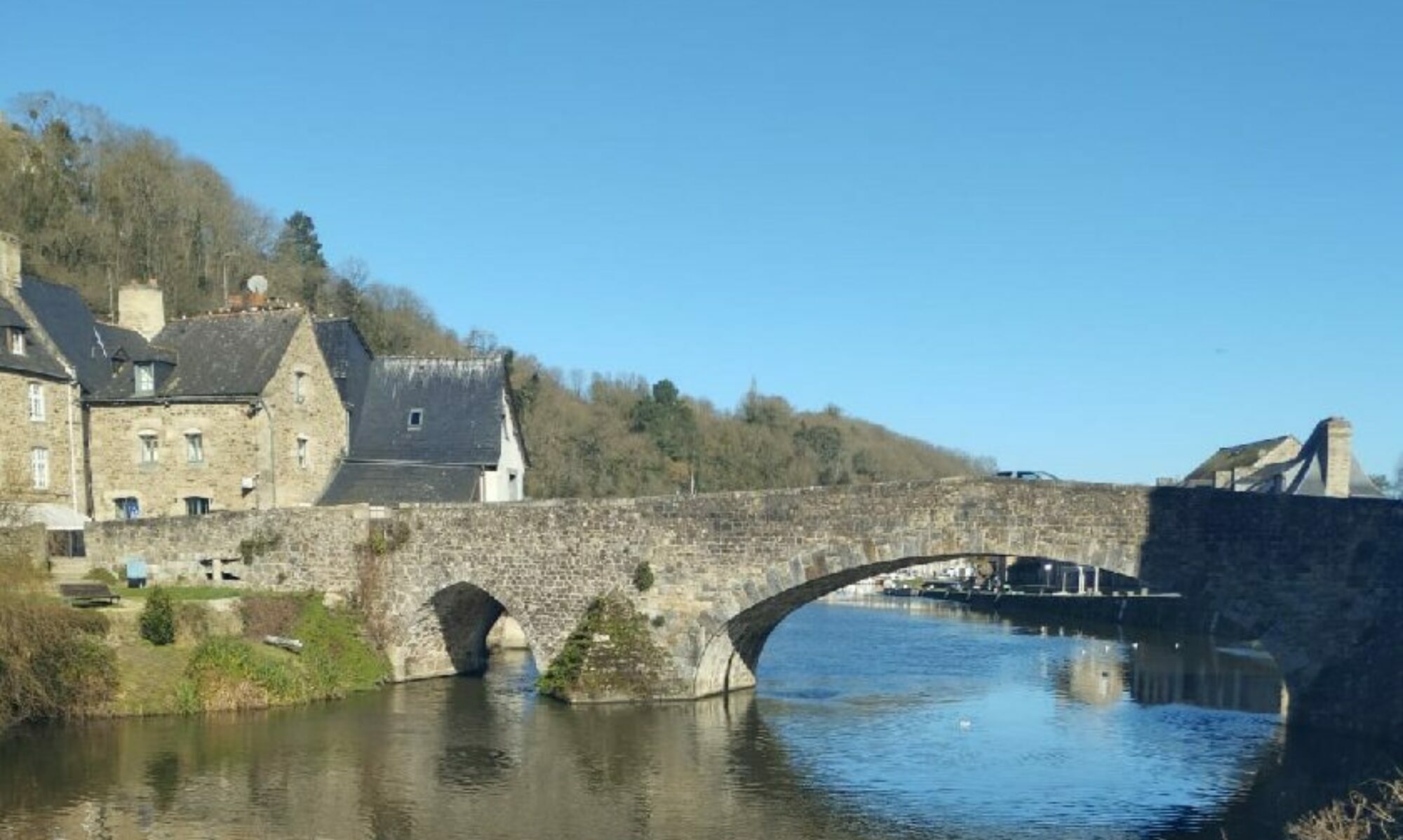 Vue sur la Rance passant sous le pont en pierre du port de Dinan